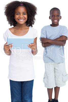 Smiling girl holding tablet pc with her brother