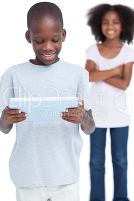 Little boy looking at a tablet pc with his sister