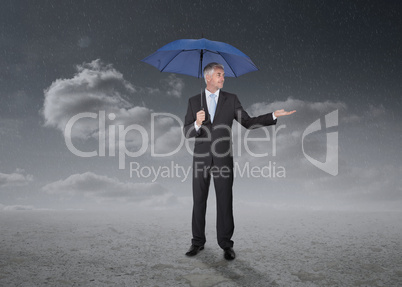 Businessman holding a blue umbrella