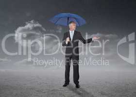 Businessman holding a blue umbrella