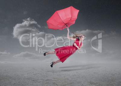 Attractive woman flying with a broken umbrella