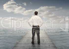 Businessman standing on a bridge with hands on hips