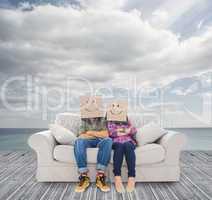 Couple sitting on couch with cardboard over their head