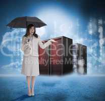 Businesswoman with umbrella in front of red servers