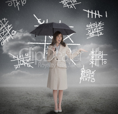 Businesswoman with noughts and crosses holding umbrella