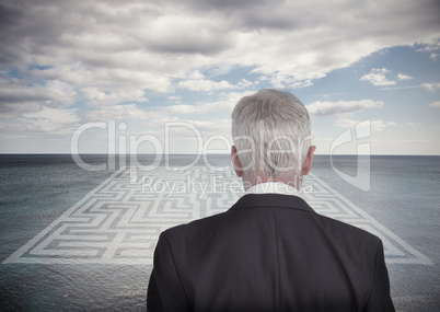 Businessman looking at landscape and maze
