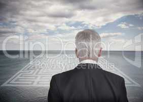 Businessman looking at landscape and maze