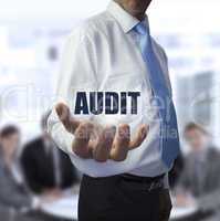 Elegant businessman holding the word audit