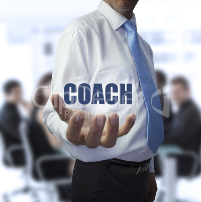 Elegant businessman holding the word coach