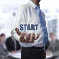 Elegant businessman holding the word start