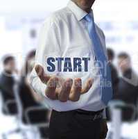 Businessman holding the word start