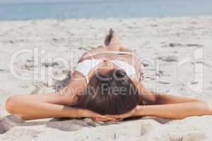 Woman lying on beach in front of ocean