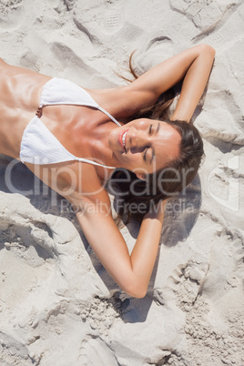 Smiling woman sunbathing on beach