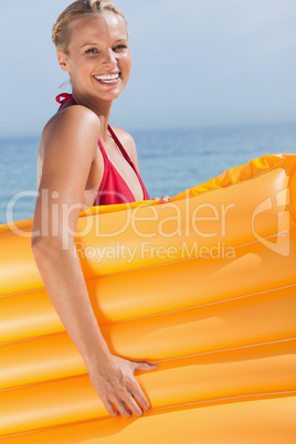 Smiling woman holding air mattress
