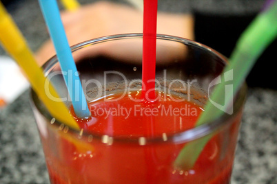 glass of tomato juice with multi-coloured tubules