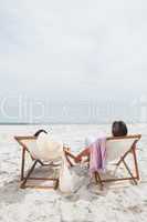 Couple looking ocean on their deck chairs