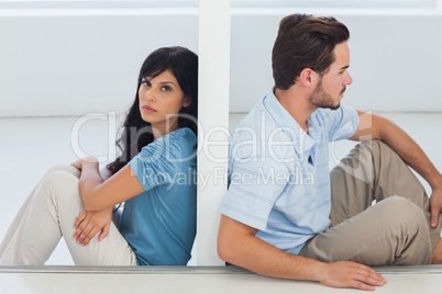 Sitting couple are separated by wall