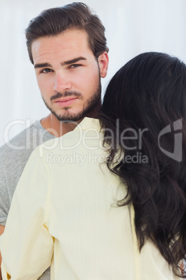 Woman giving hug to unsmiling boyfriend
