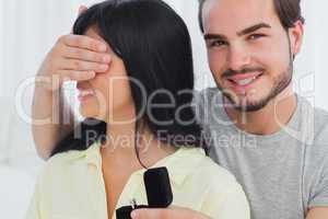 Smiling man about to propose hiding eyes of his girlfriend