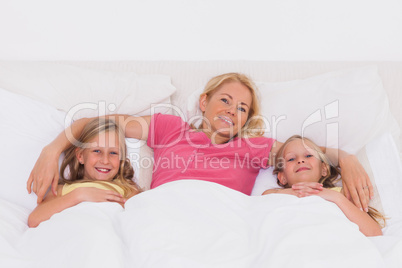 Woman lying in bed with her children