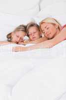 Woman sleeping in bed with her children