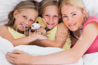 Woman napping in bed with her cute children