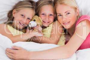 Woman napping in bed with her cute children