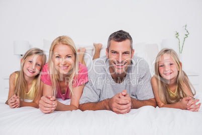 Parents lying in bed with their children