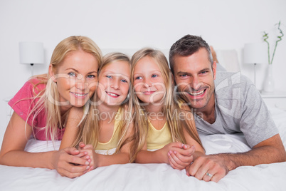 Portrait of parents lying in bed with their children