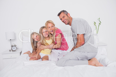 Parents playing in bed with their twins