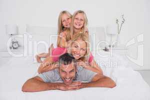 Happy man giving a piggy back to his family