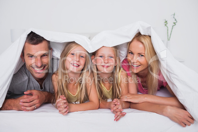 Family playing under the quilt