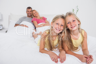 Twins posing in bed in front of their parents
