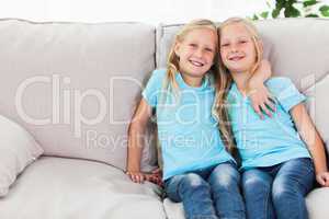 Blonde twins sitting on a couch