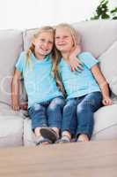Cute twins sitting on a couch