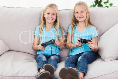 Portrait of twins playing video games together
