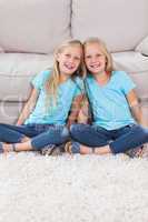 Young twins sitting on a carpet
