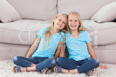Twins sitting on a carpet