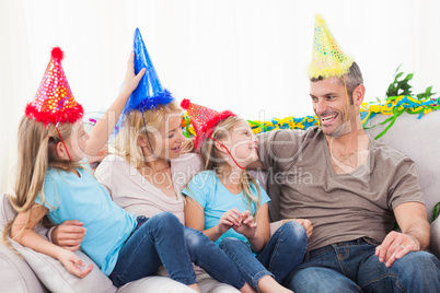 Family celebrating twins birthday sitting on a couch