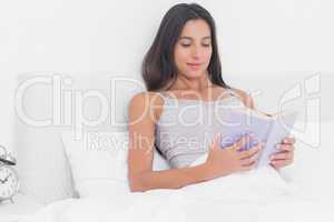 Woman reading a book in bed