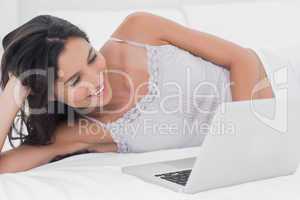 Woman using her laptop in bed