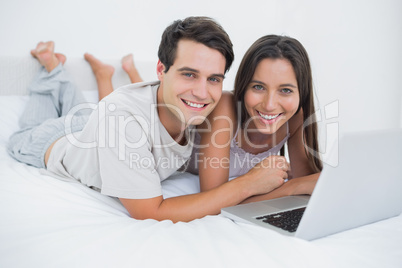 Young couple lying together in bed