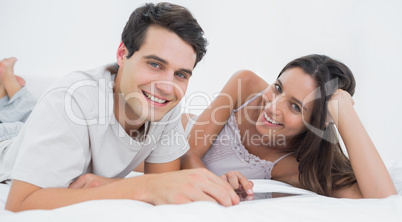 Portrait of a couple using a tablet lying in bed