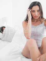 Woman feeling worried sitting in bed