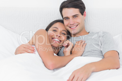 Woman embracing her partner in bed