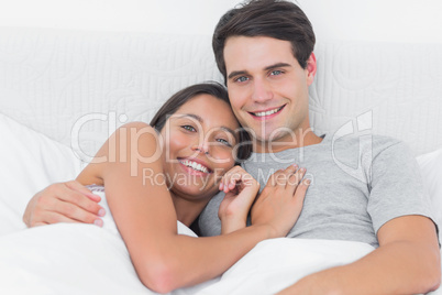 Woman embracing her boyfriend in bed