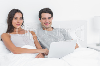 Portrait of a cheerful couple using a laptop