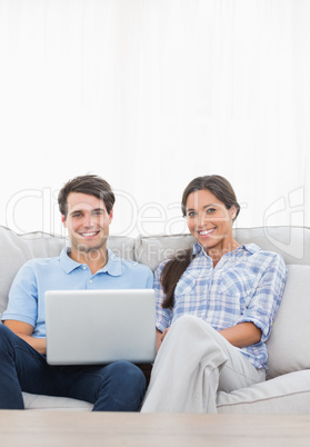 Portrait of a couple relaxing with a laptop