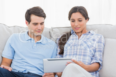 Couple relaxing with a tablet