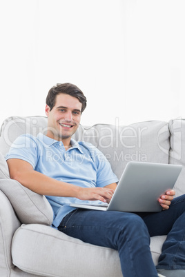 Portrait of a cheerful man using his laptop